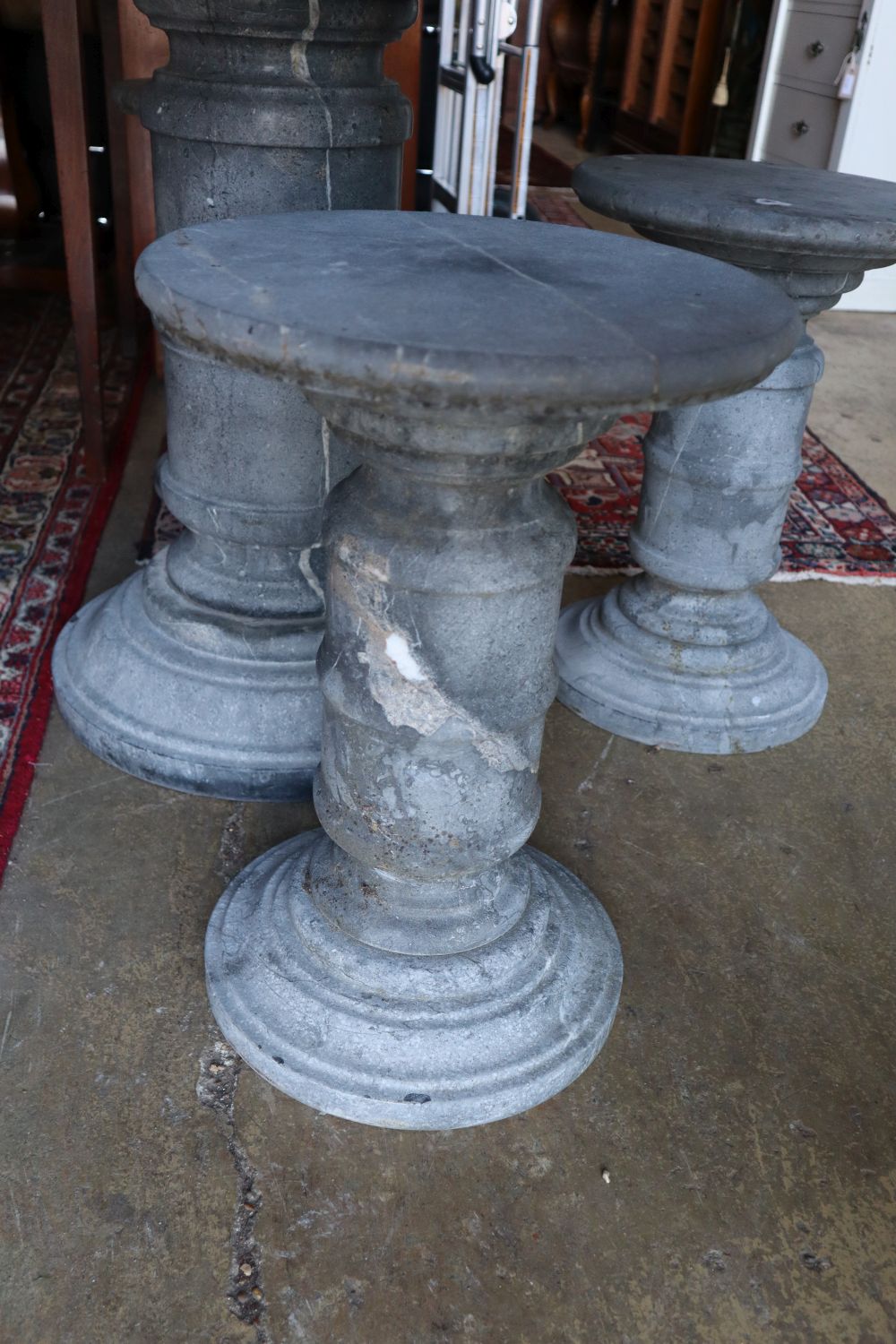 A circular reconstituted stone garden table, 100cm diameter, 80cm high and four matching stools,